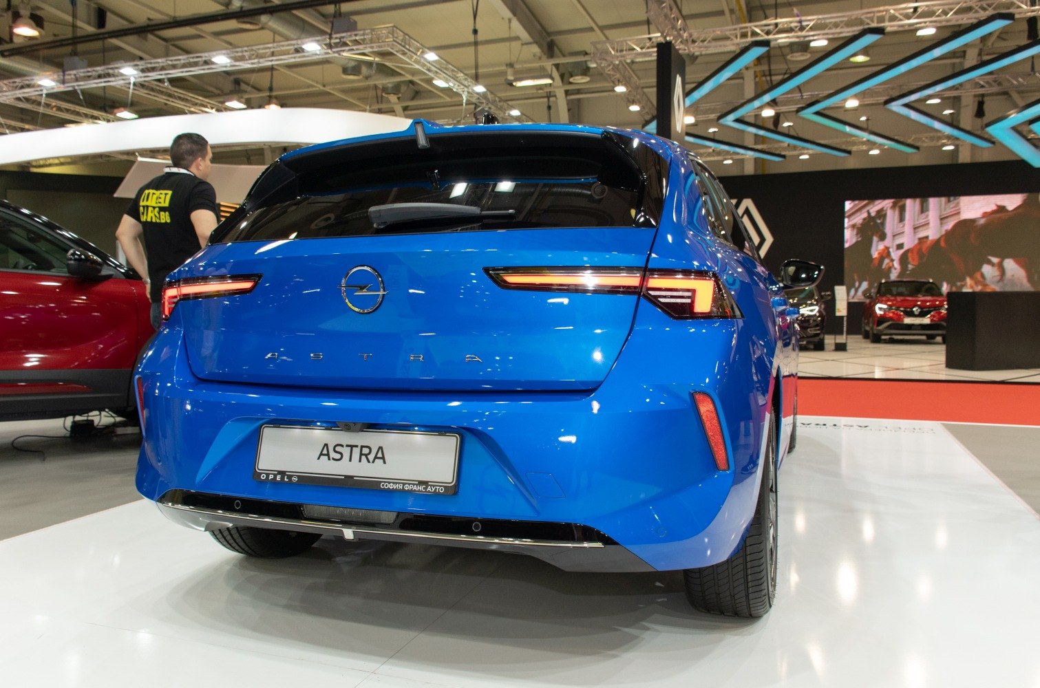 Rear view of hatchback with illuminated LED tail lights and blue glossy finish