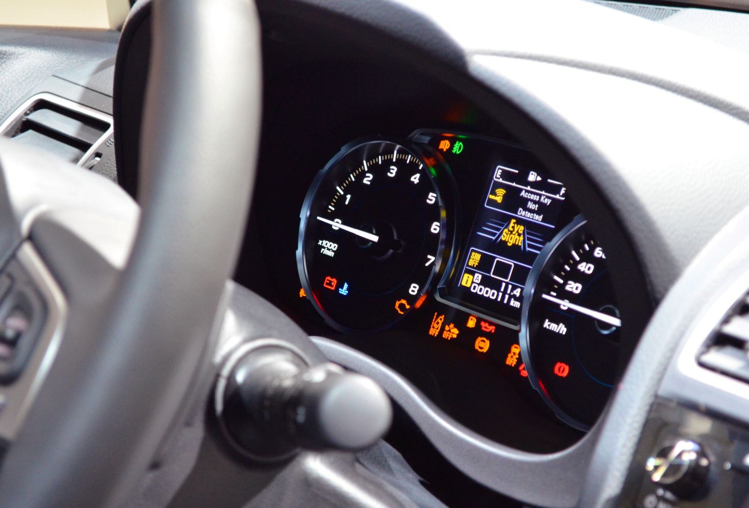 Instrument cluster with gauges and digital dashboard displaying EyeSight system and warning lights.