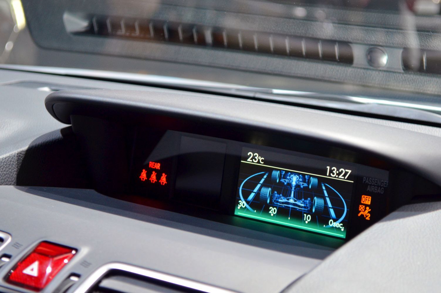 Dashboard digital display showing drivetrain layout and seatbelt warnings