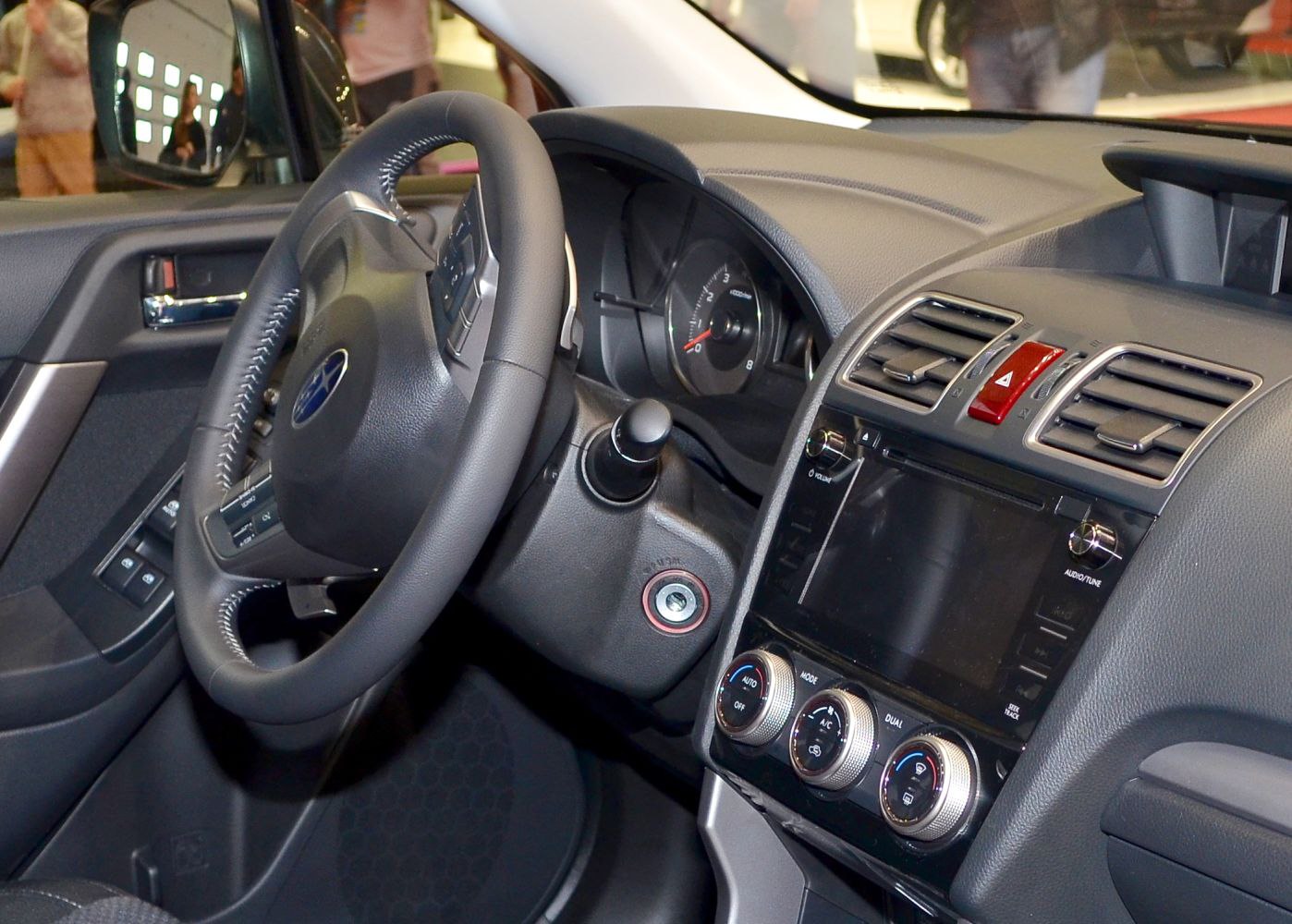 Interior dashboard and steering wheel with control dials and infotainment screen