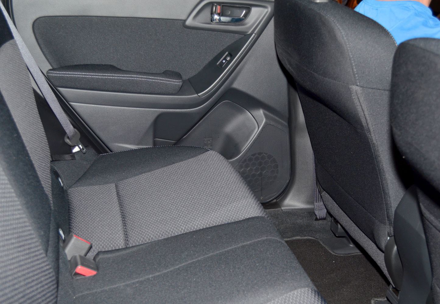 Rear passenger seat and door panel with speaker and window control.