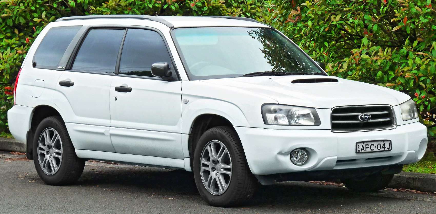 White SUV front side view with roof rails and hood scoop
