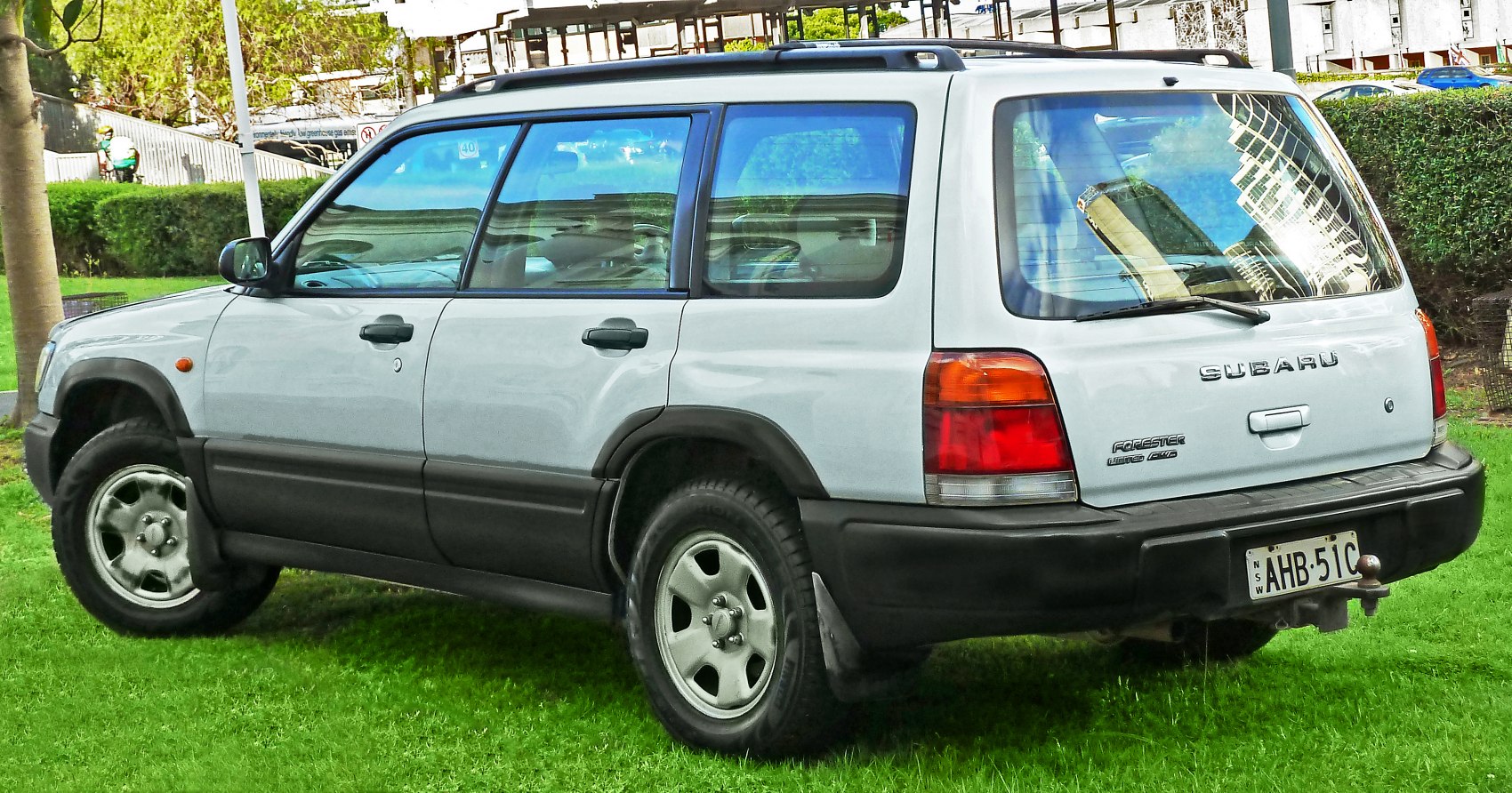 White SUV rear side view with roof rails and rugged lower body cladding