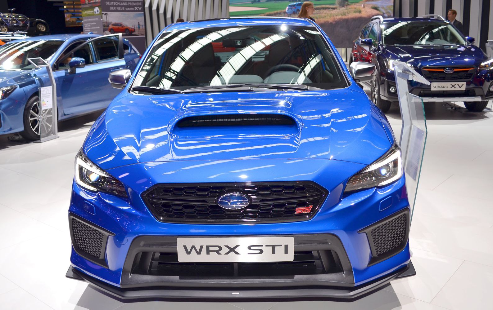 Blue car front with large hood scoop and honeycomb grille
