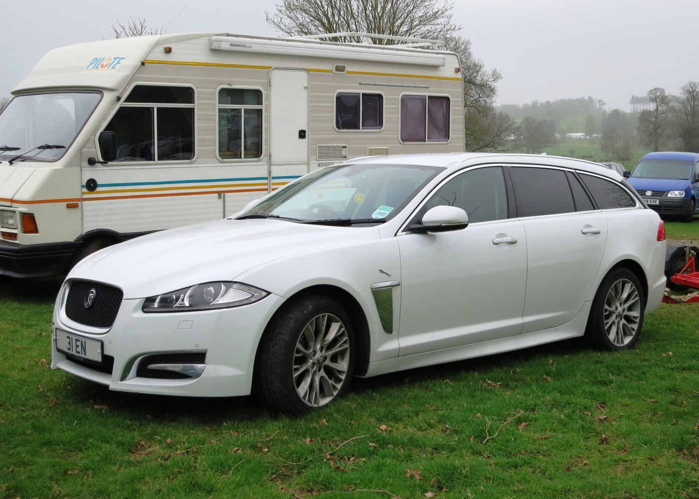 Front side view of a white wagon with sleek headlights and alloy wheels.