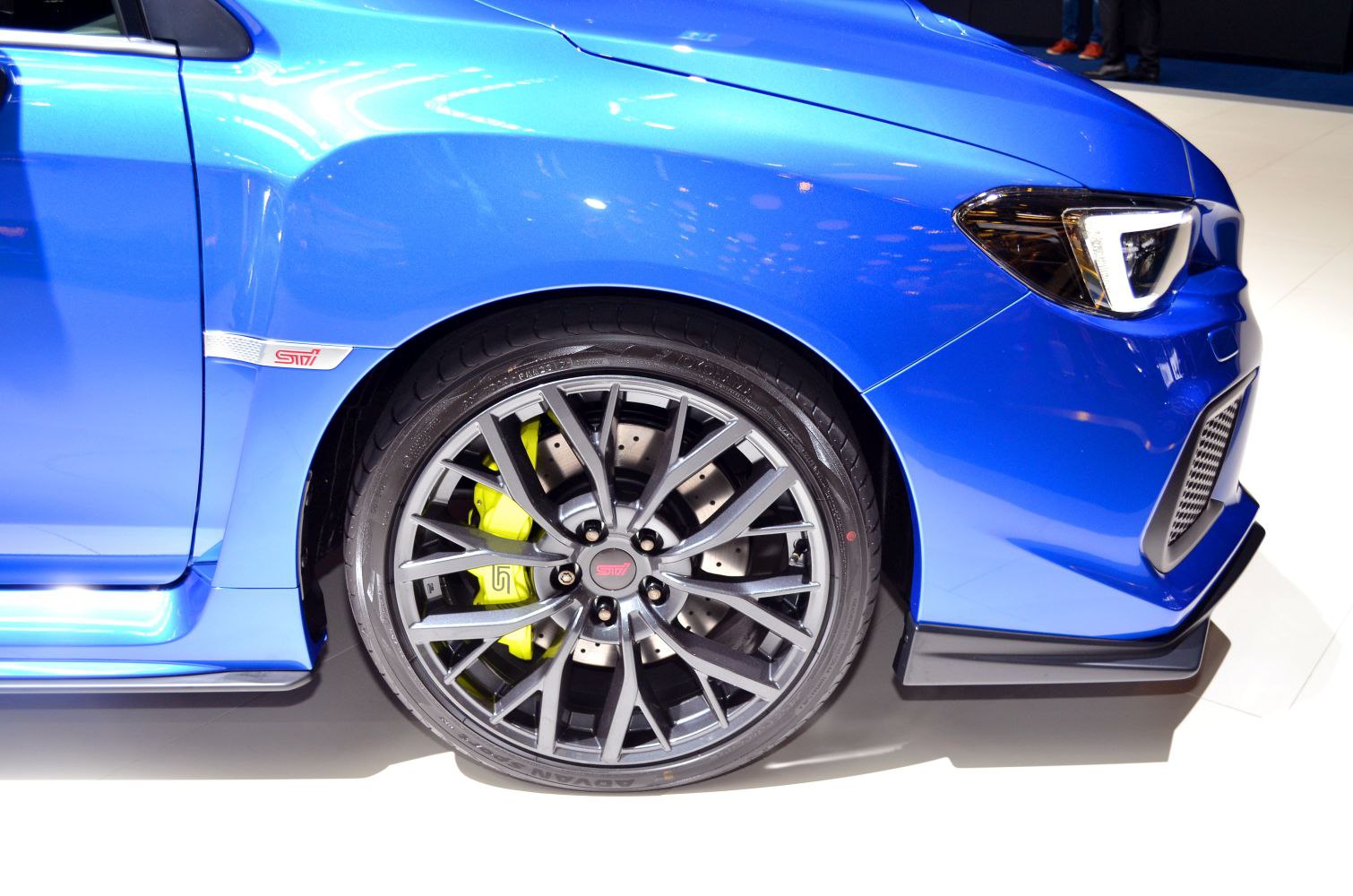 Front wheel with yellow brake caliper and sporty blue fender