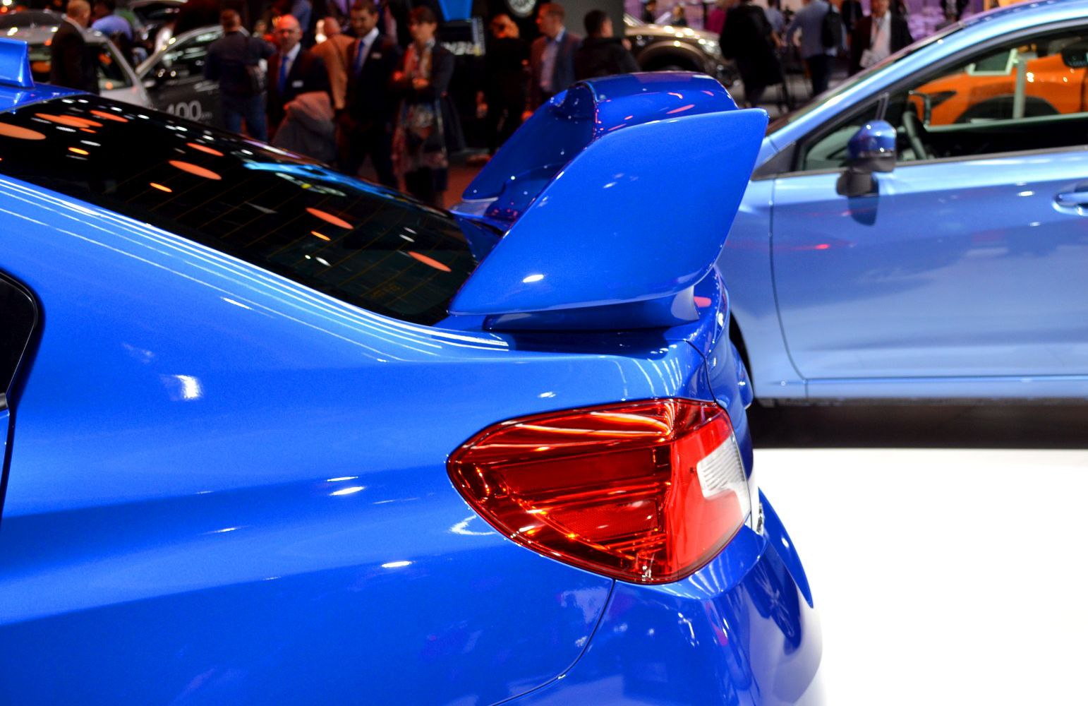 Large blue rear wing and red tail light on a sporty sedan.