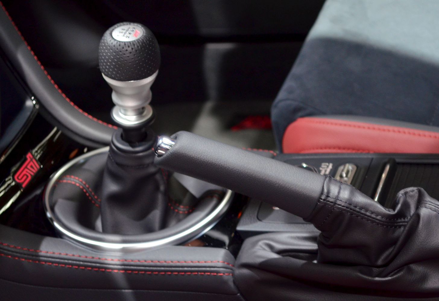Manual gear knob and handbrake lever with red stitching and leather