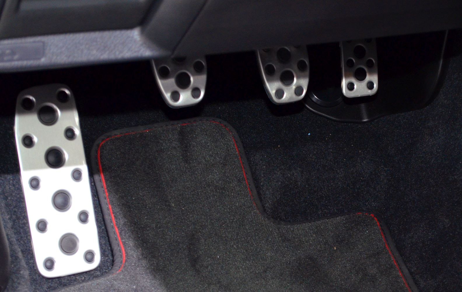 Sporty metal pedal set with floor mat featuring red stitching