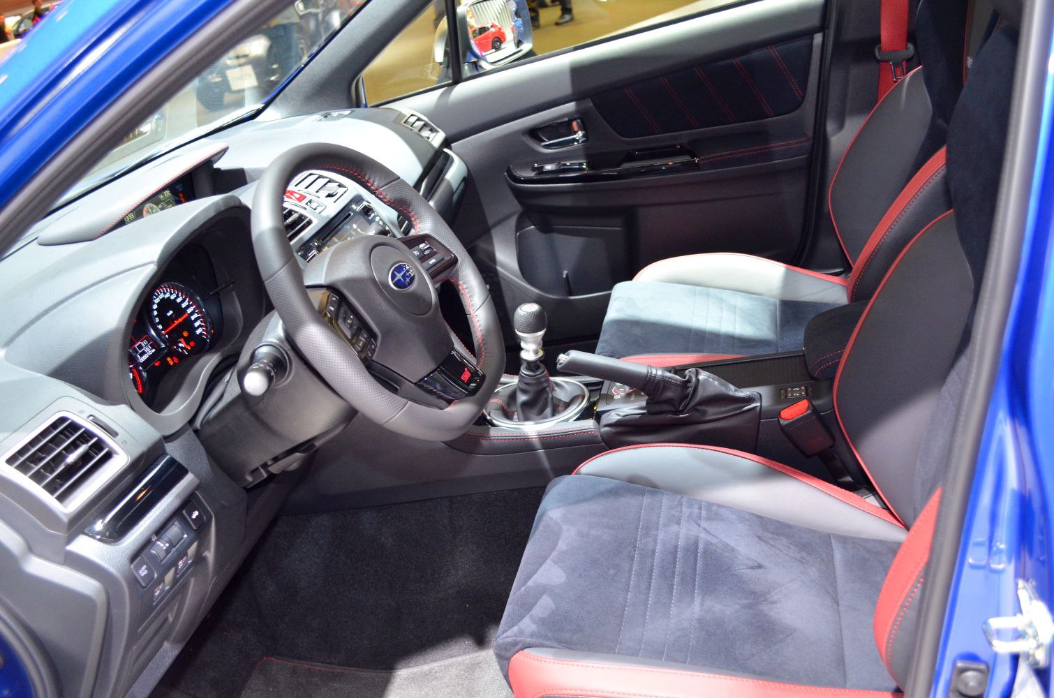 Manual gearbox and sporty seats with red accents in car interior