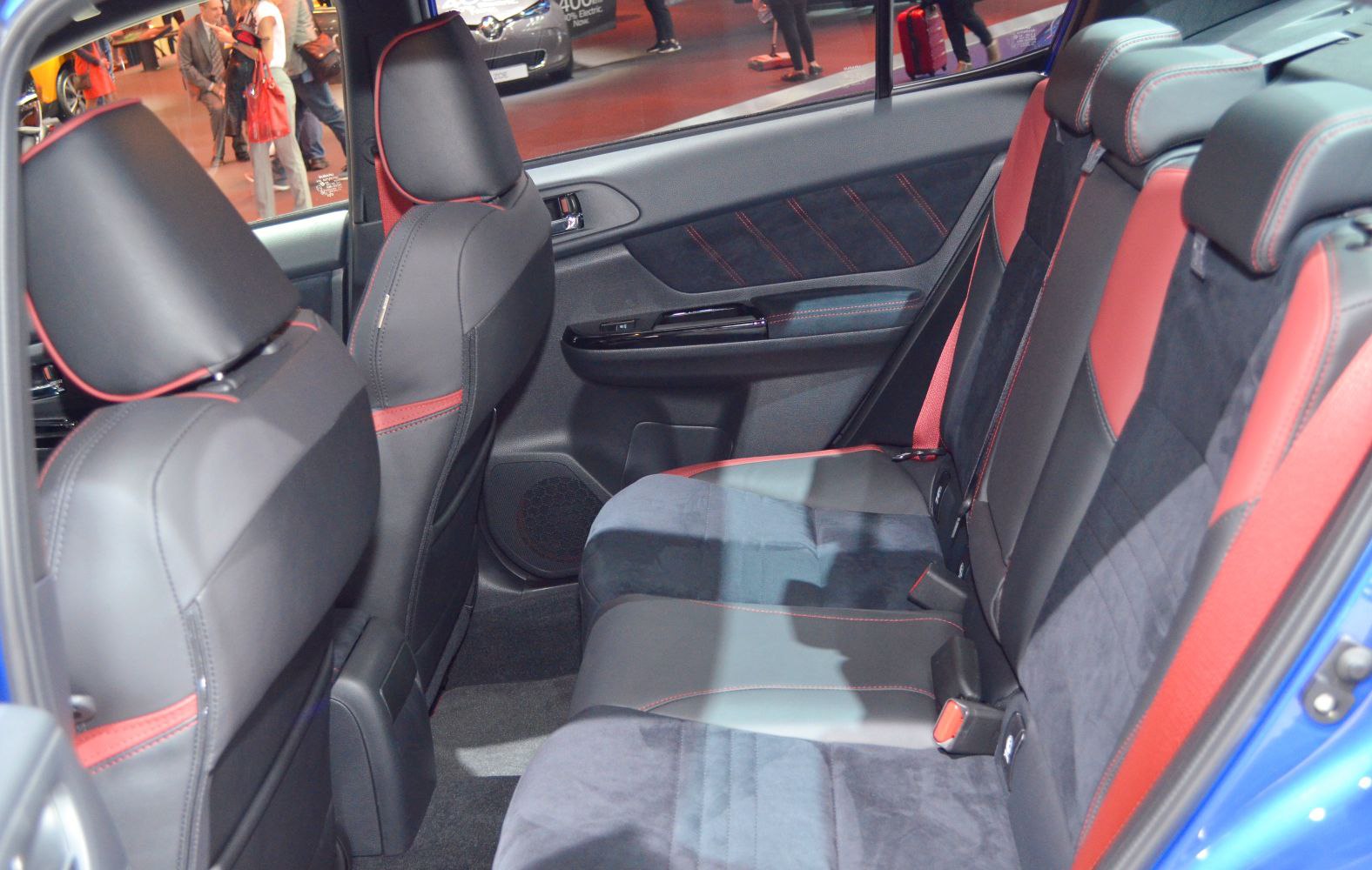 Rear seat cabin with black and red sports upholstery and door panel.
