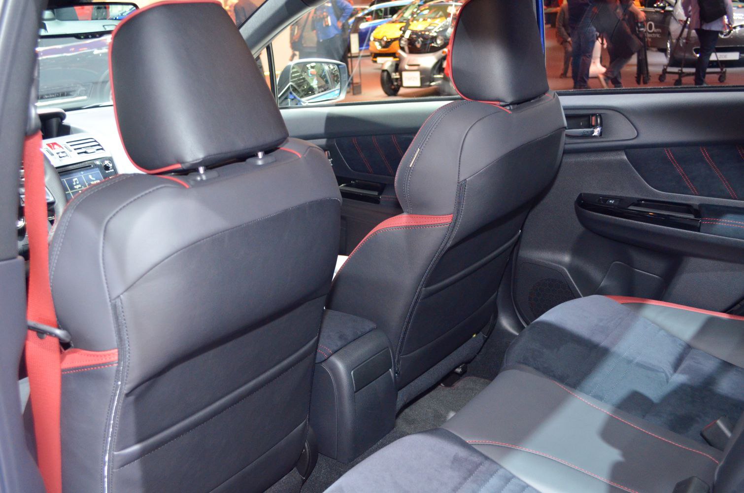 Rear interior with black leather and red stitching, red seat belts