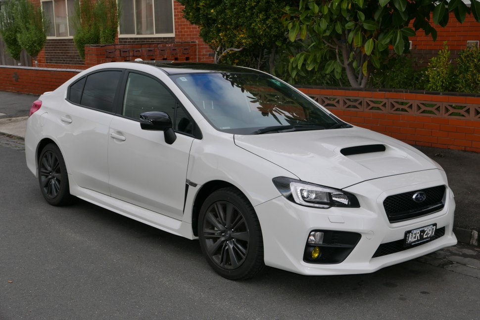 White sedan with hood scoop and black wheels parked on street