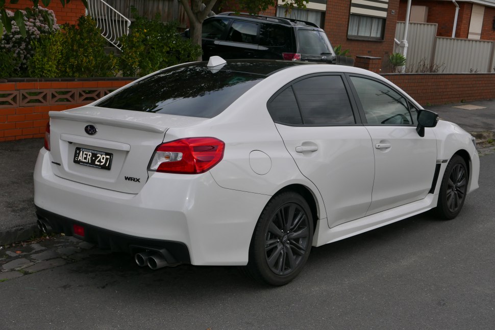 White sporty sedan rear side view with quad exhaust and tinted windows