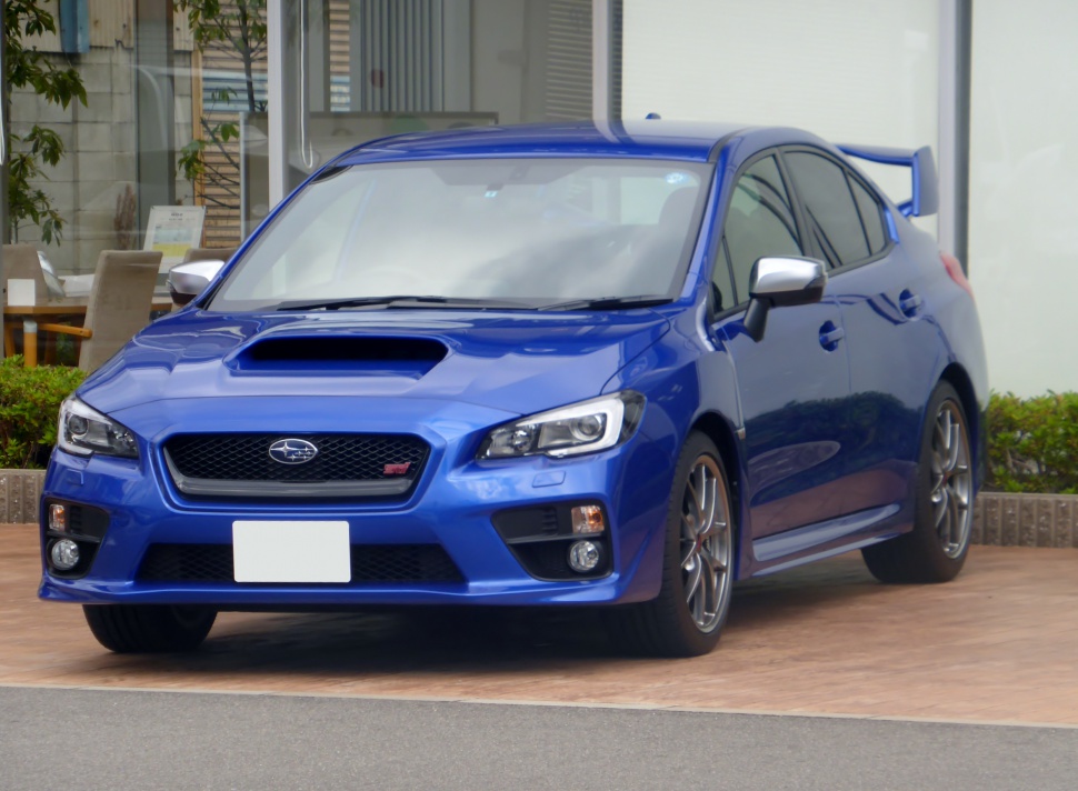Front view with hood scoop, grille, sporty headlights, alloy wheels, rear spoiler