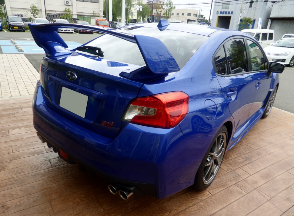 Rear view of a sporty sedan with large spoiler and dual exhausts