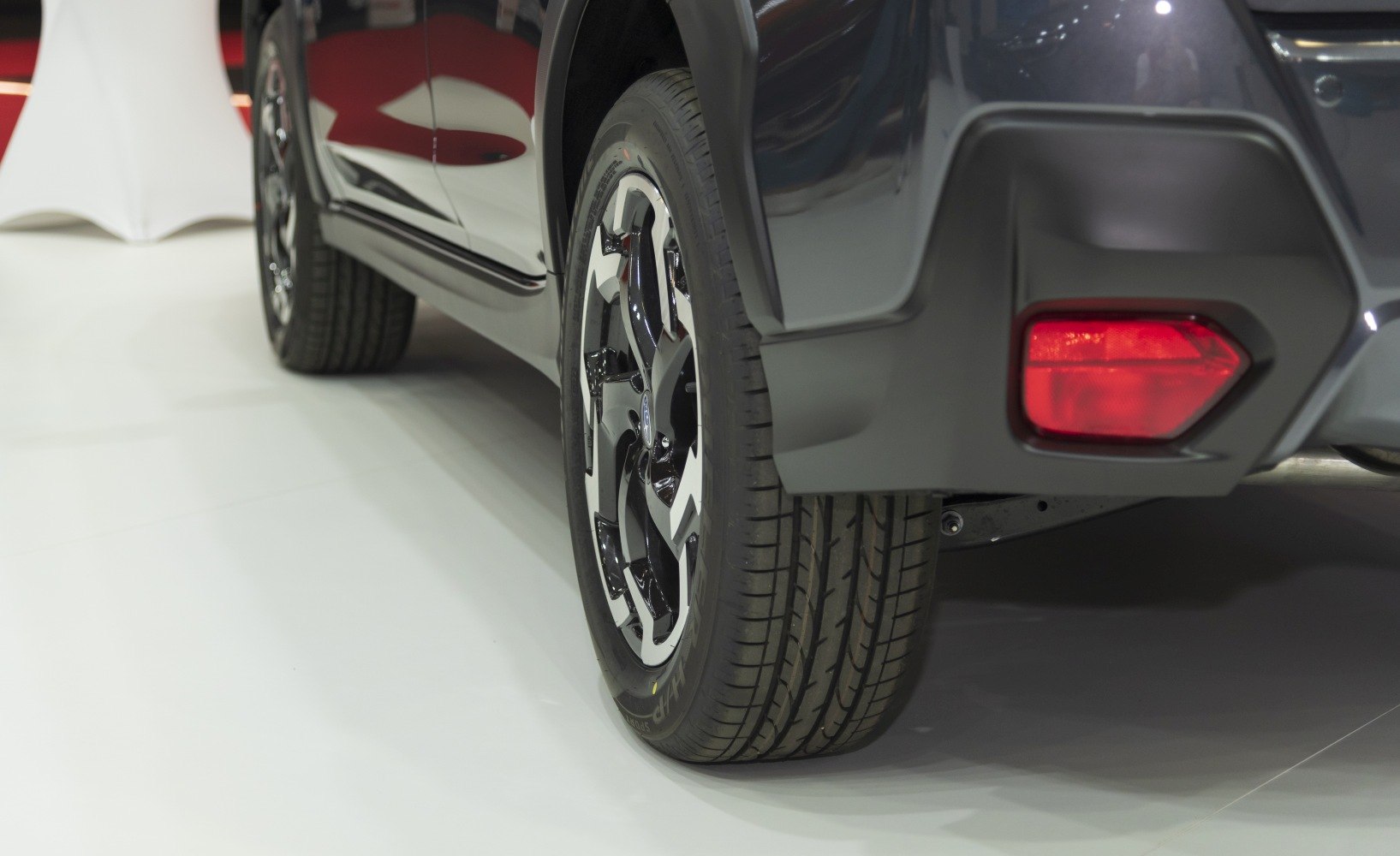 Close-up of alloy wheel and rear reflector with tire tread