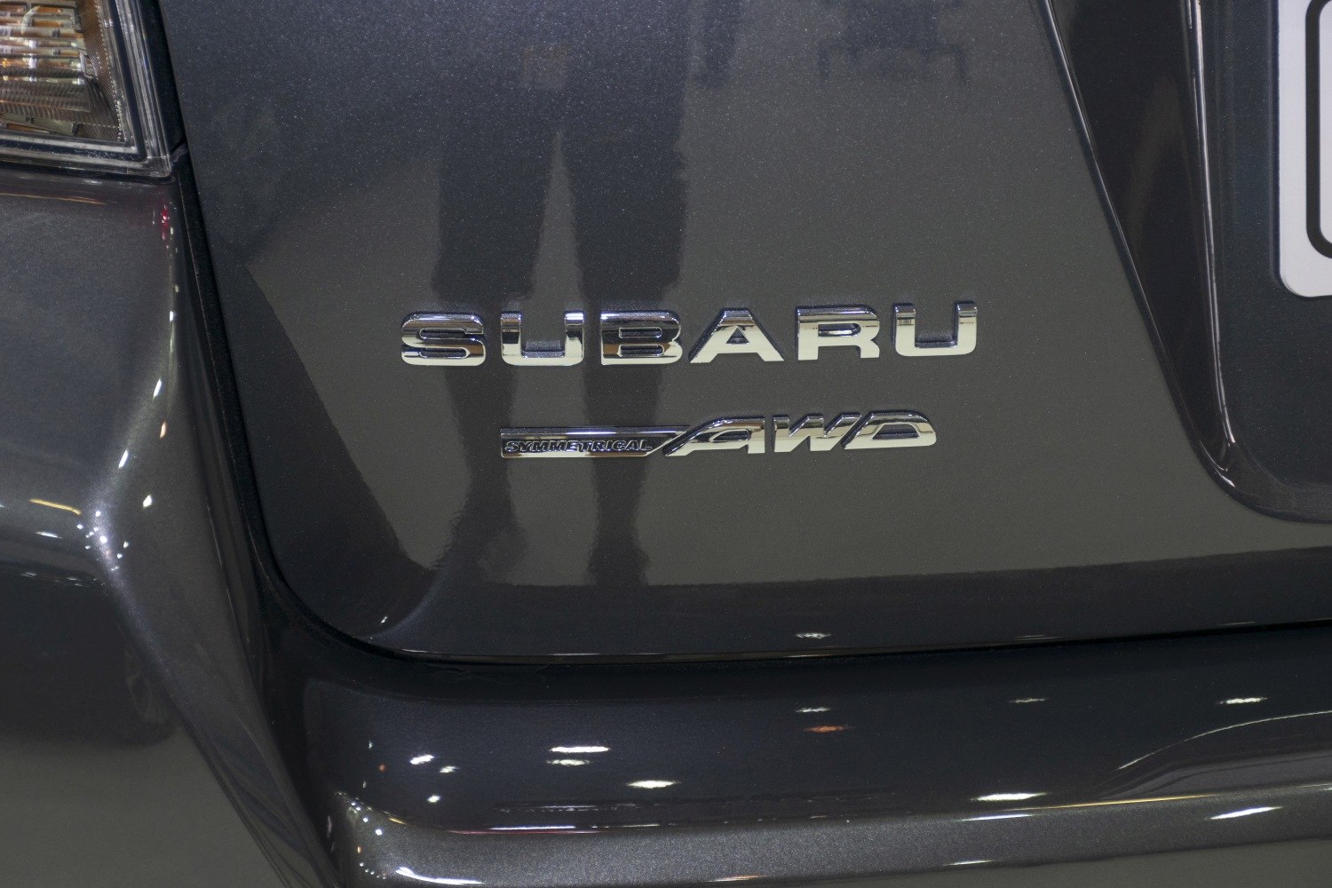 Close-up of AWD badge and Subaru emblem on car rear