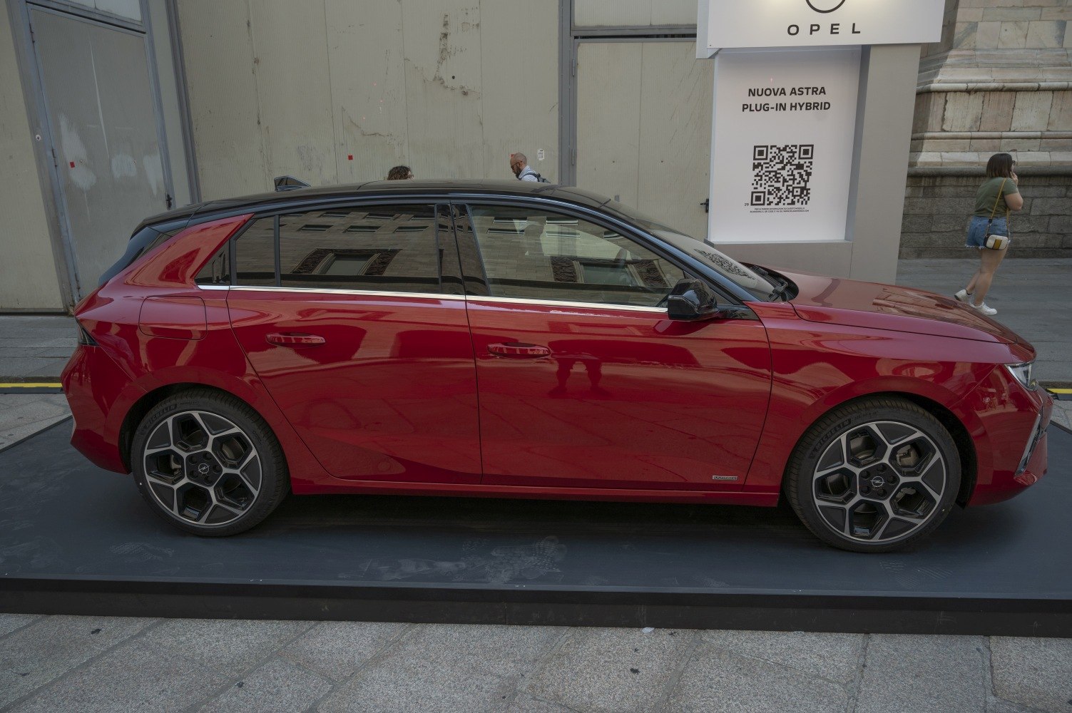 Sleek red hatchback side profile with distinct alloy wheels