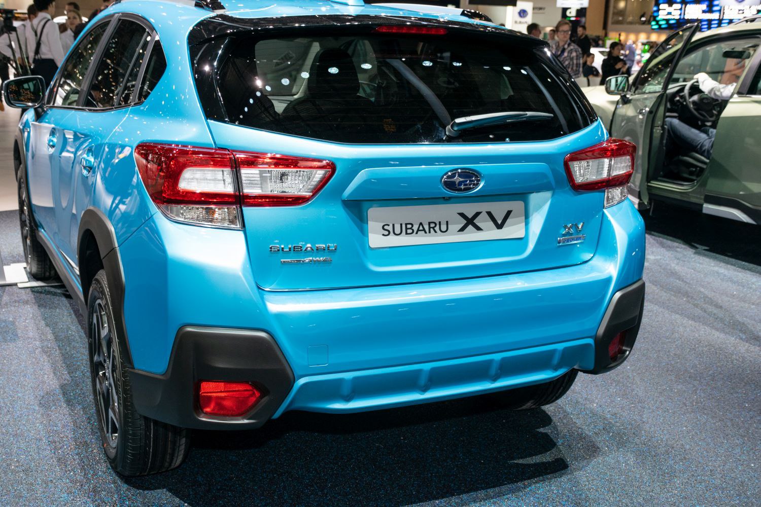 Rear view with taillights and rear bumper of a light blue compact SUV