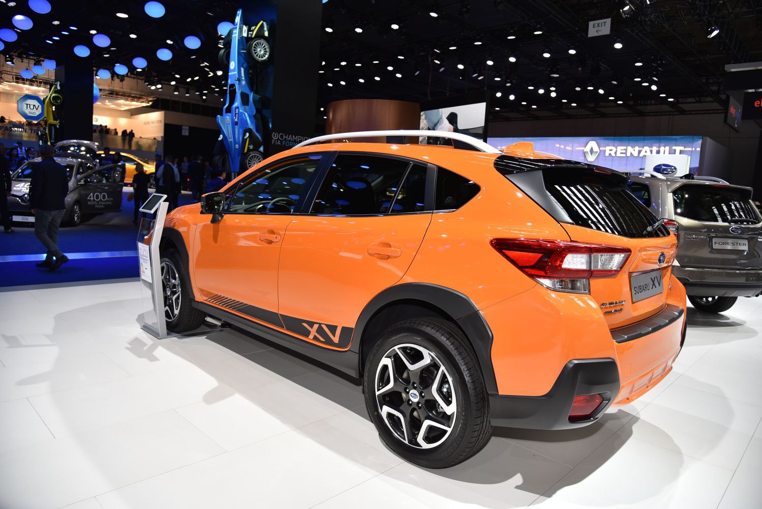 Orange crossover with black trim and alloy wheels, rear side view