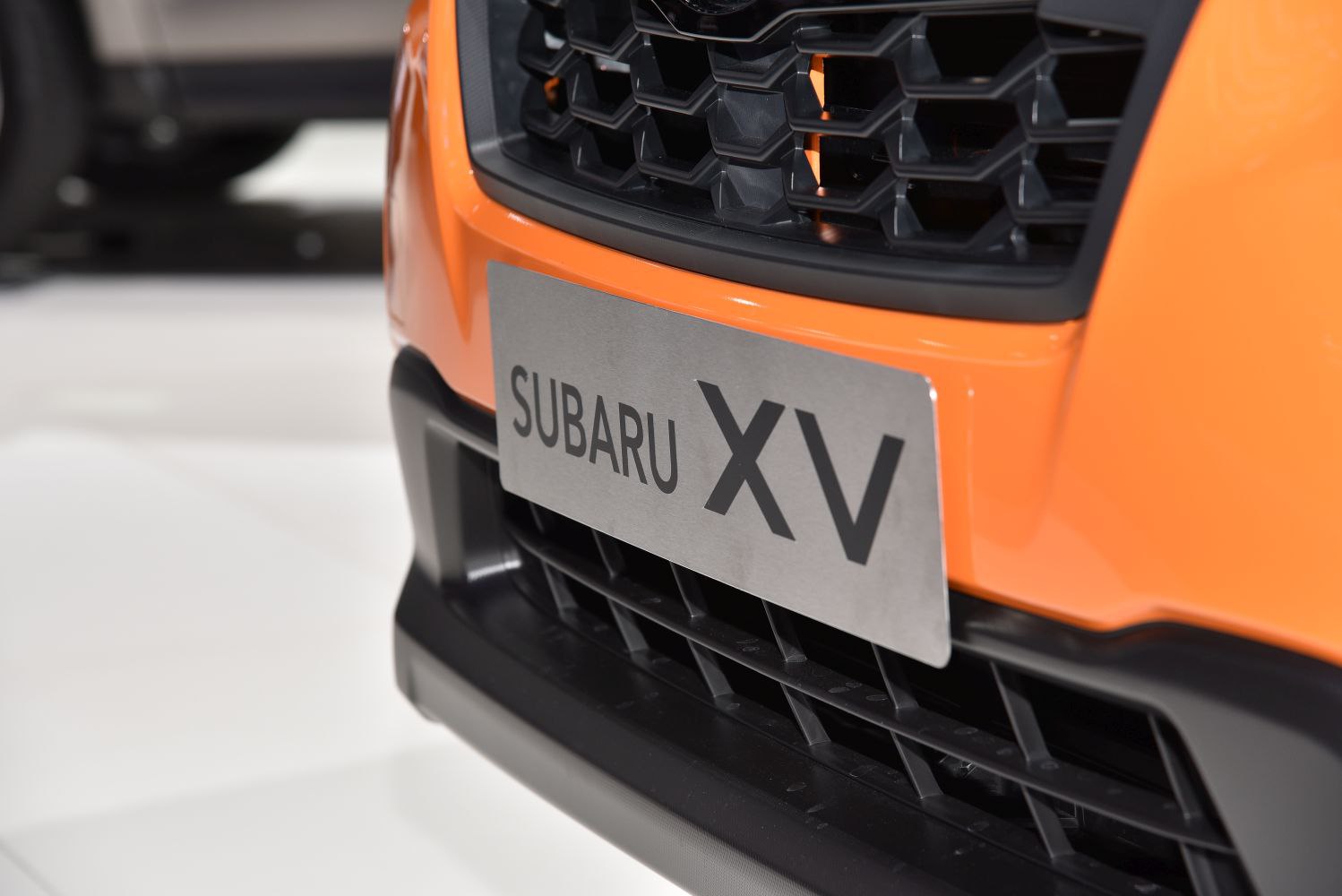 Front grille and license plate of an orange vehicle