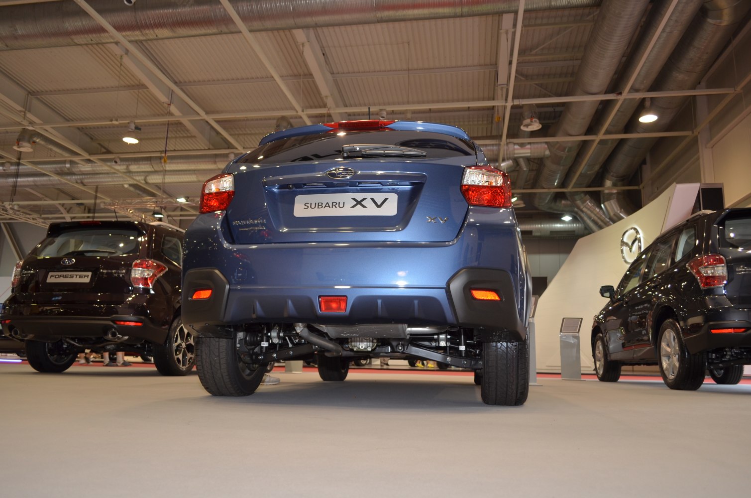 Rear view with visible suspension and taillights in showroom.