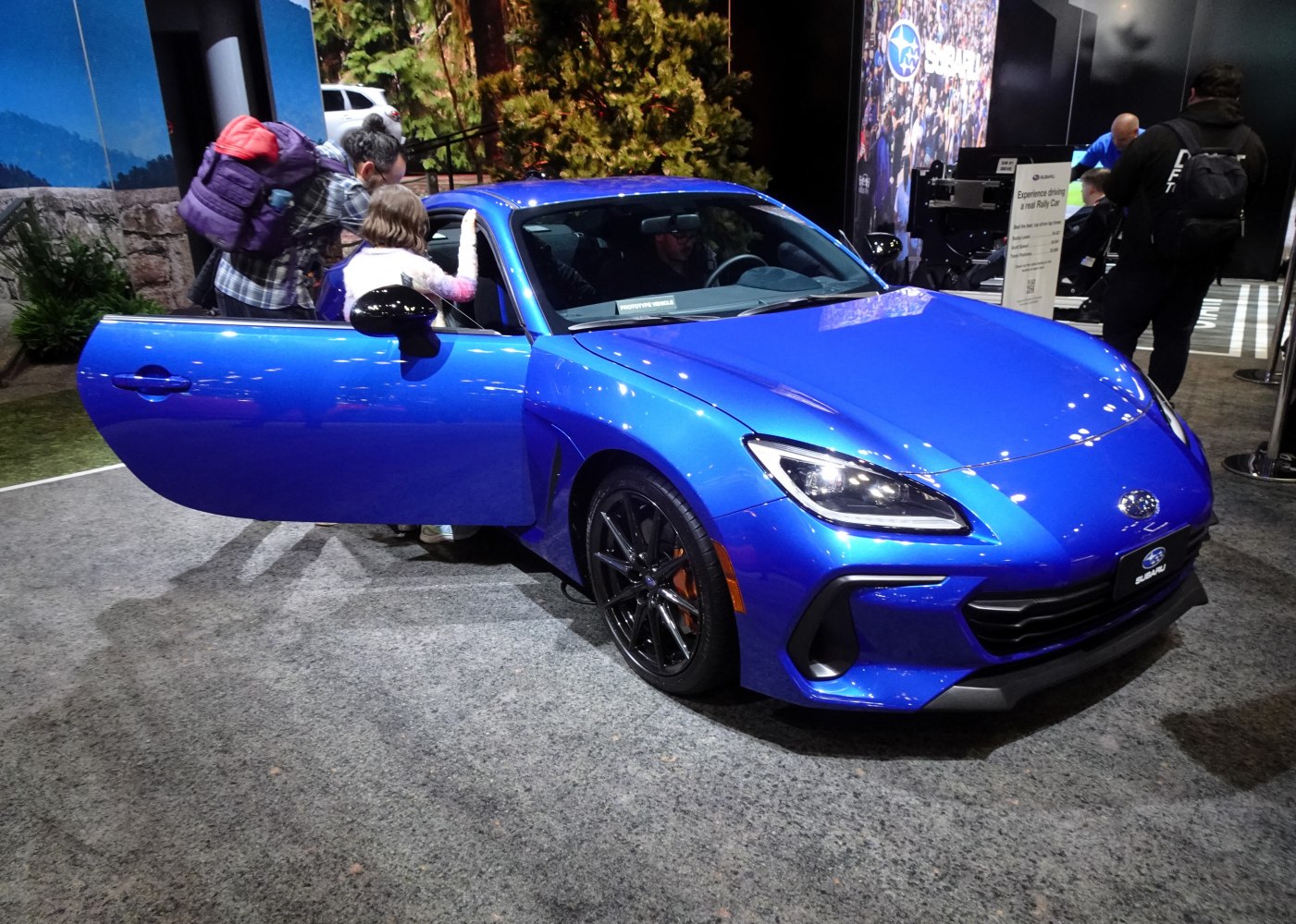 Front view of sporty coupe with open door and visible wheel design
