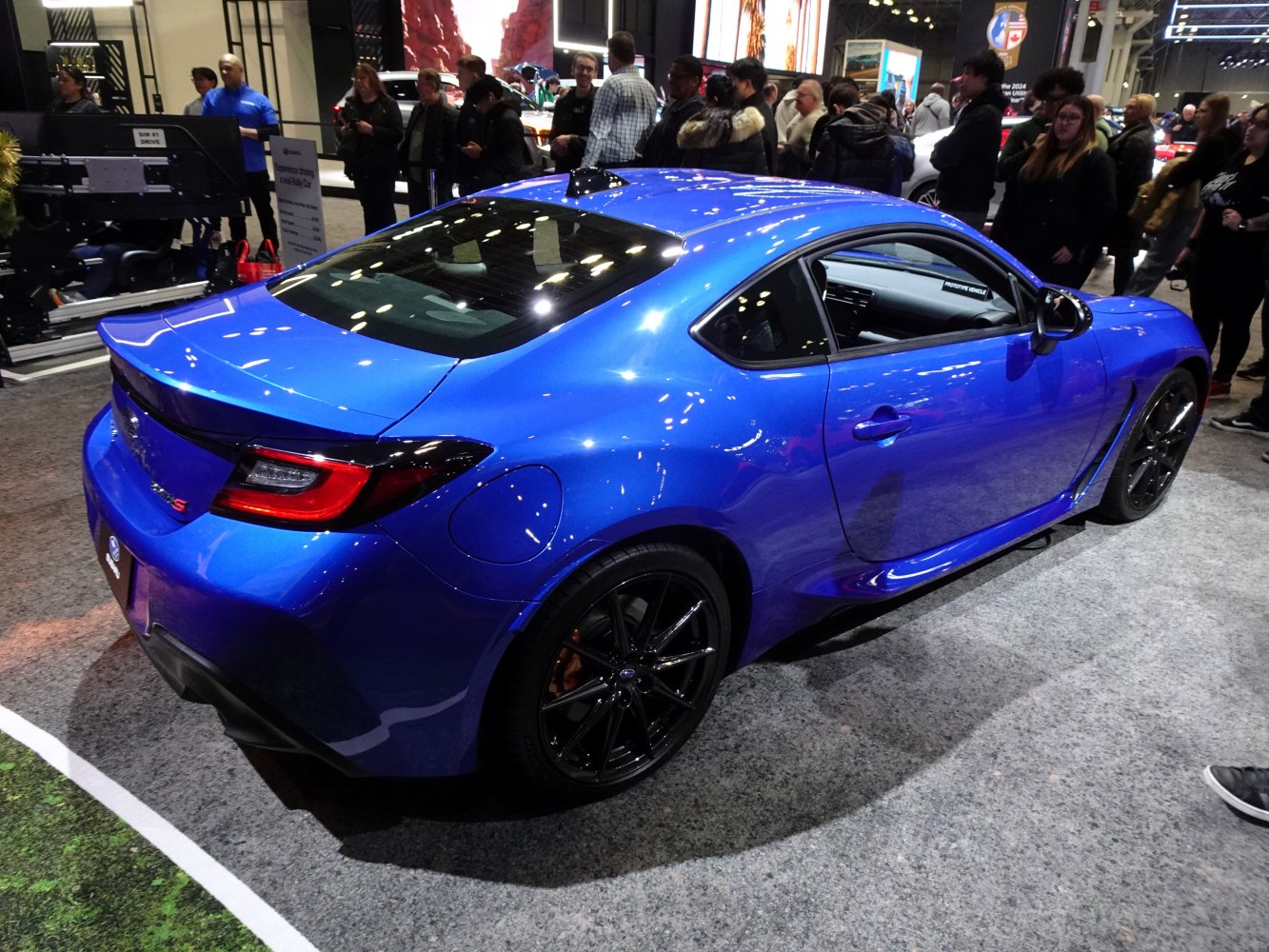 Blue sports coupe with rear spoiler and black wheels