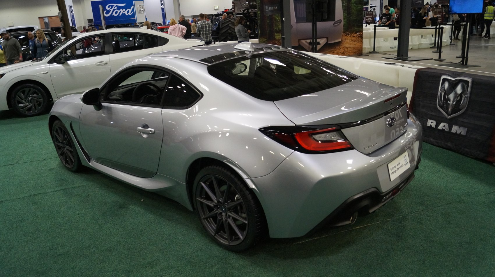 Rear side view of a sporty coupe with modern tail lights and silver paint