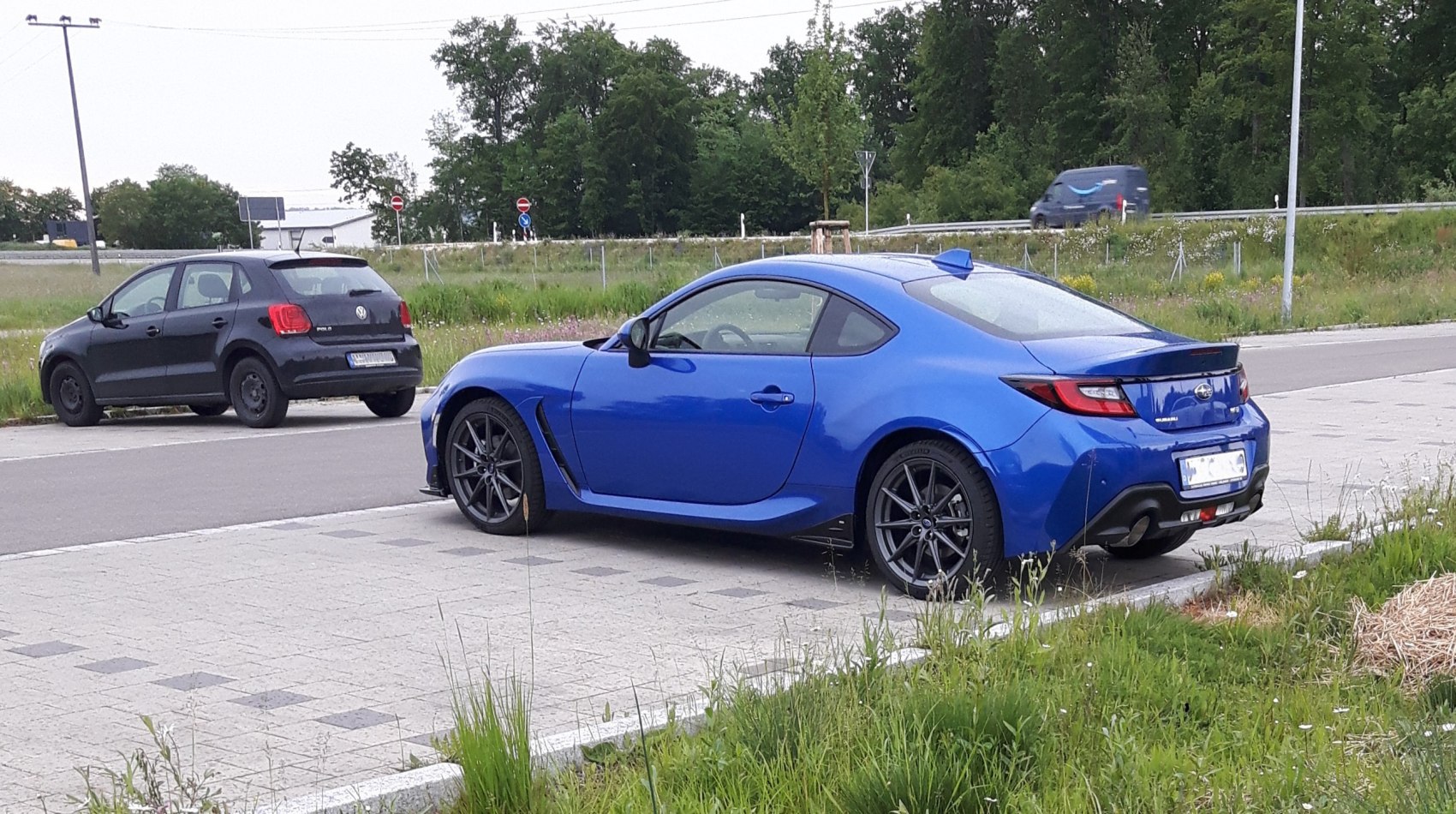 Blue sporty coupe showing rear and side profile with shark fin antenna