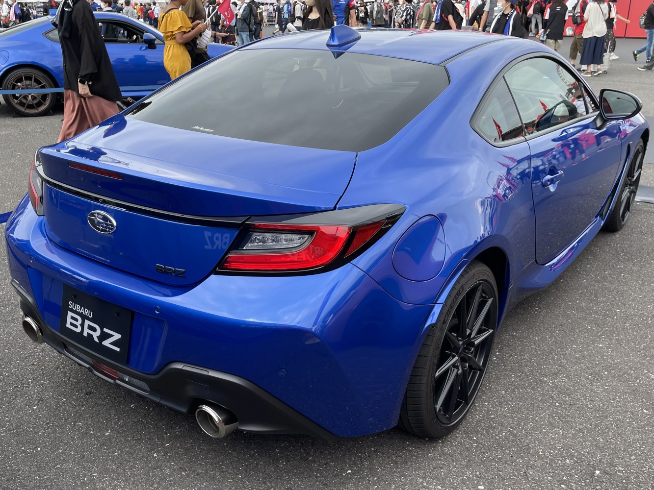 Rear view of blue sports coupe with LED tail lights and dual exhaust pipes