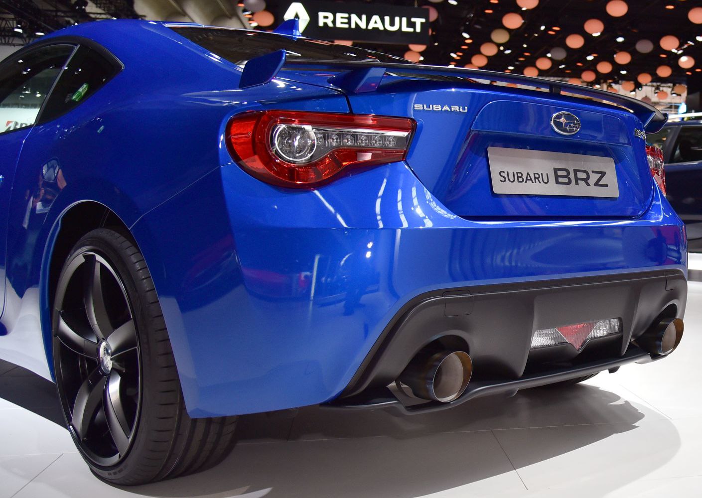 Rear view of a blue sports coupe with dual exhaust and distinctive taillights