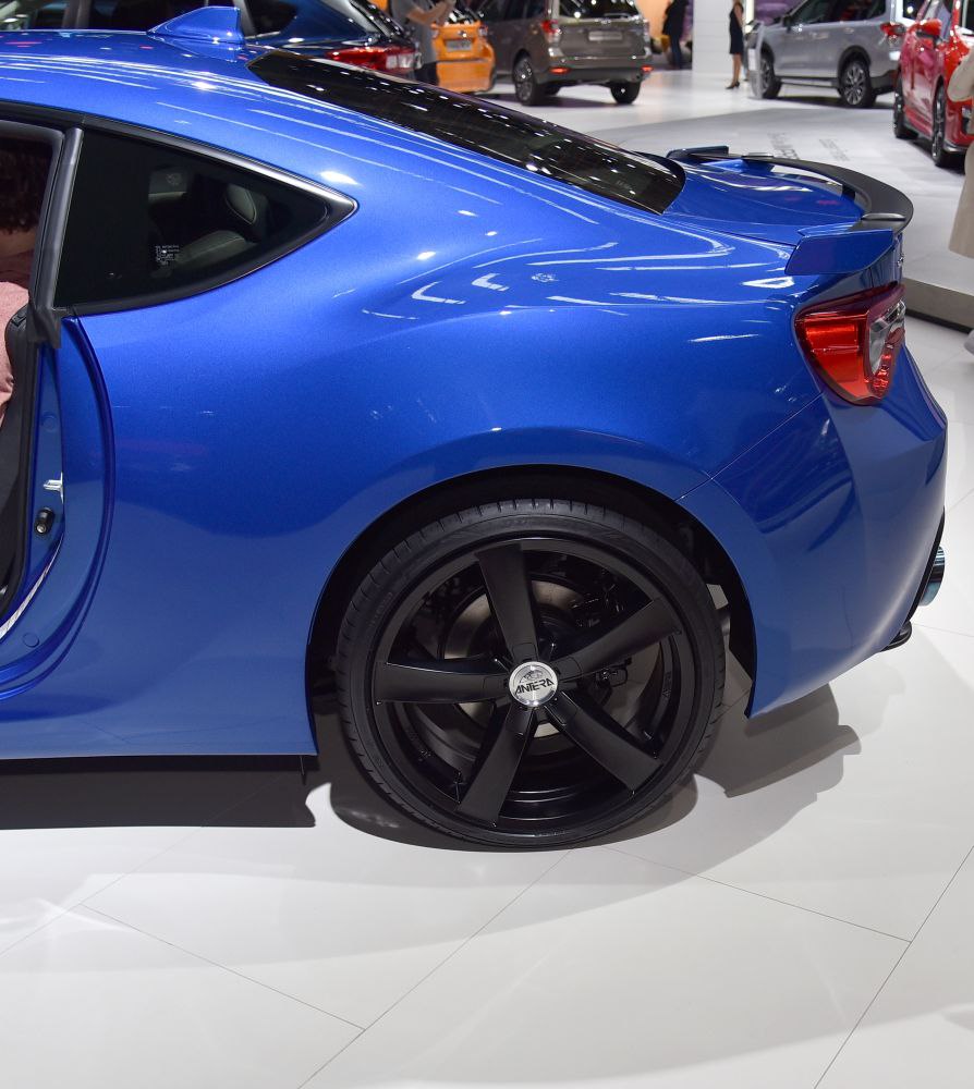 Rear side and black six-spoke wheels of a sports coupe