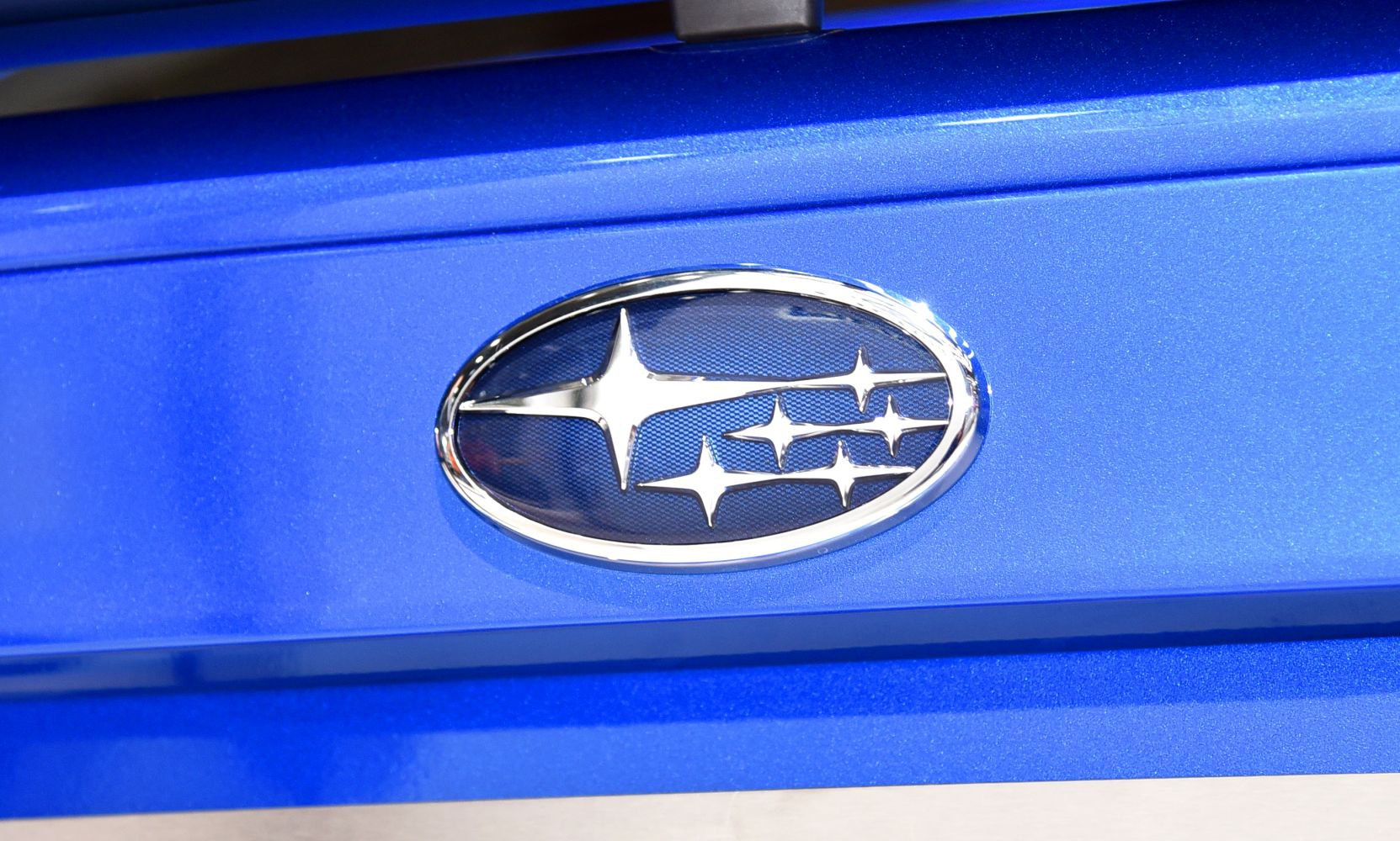 Close-up of Subaru logo on blue car panel