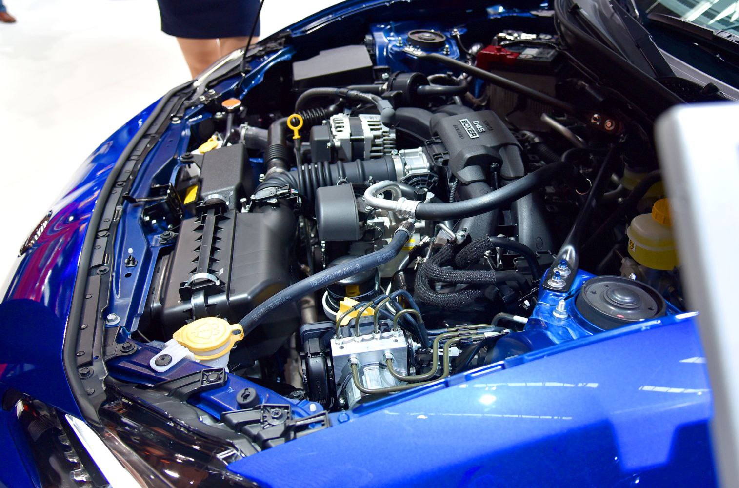 Detailed engine bay with visible 2.0L Boxer engine and fluid reservoirs.