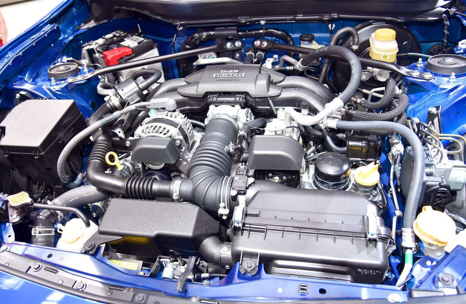Boxer engine layout with air intake and mechanical components in engine bay