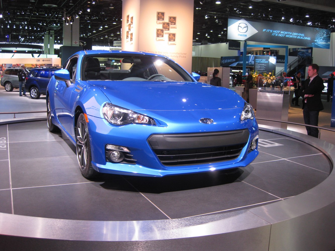 Blue sporty coupe front view on rotating platform