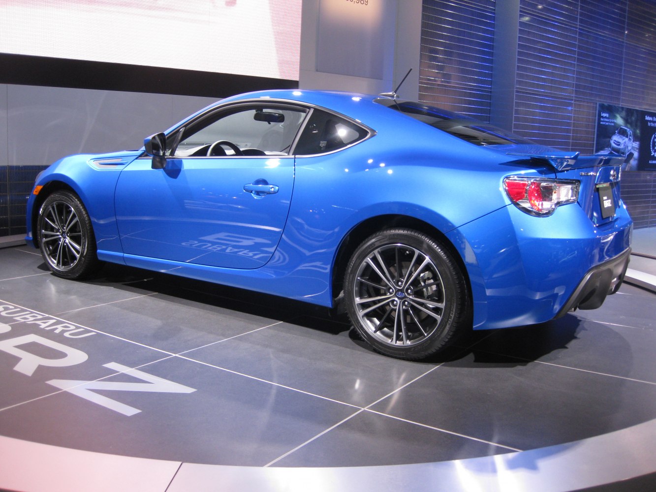 Rear-side view of sporty coupe with alloy wheels and rear spoiler
