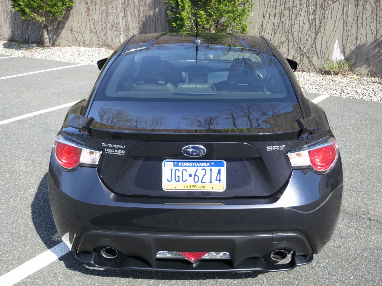 Rear view with taillights, spoiler, dual exhaust, license plate