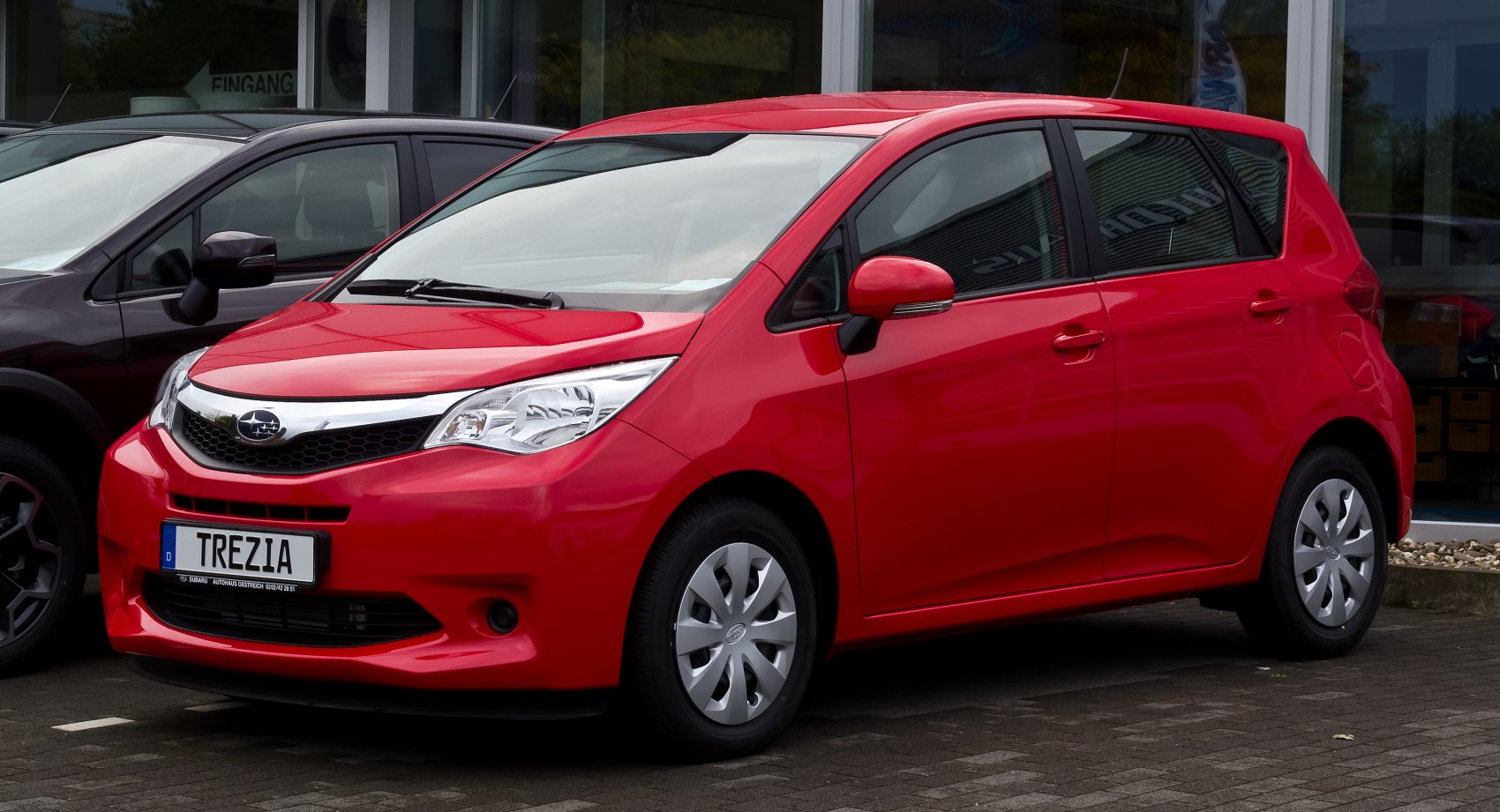 Red compact hatchback with sharp headlights and chrome grille