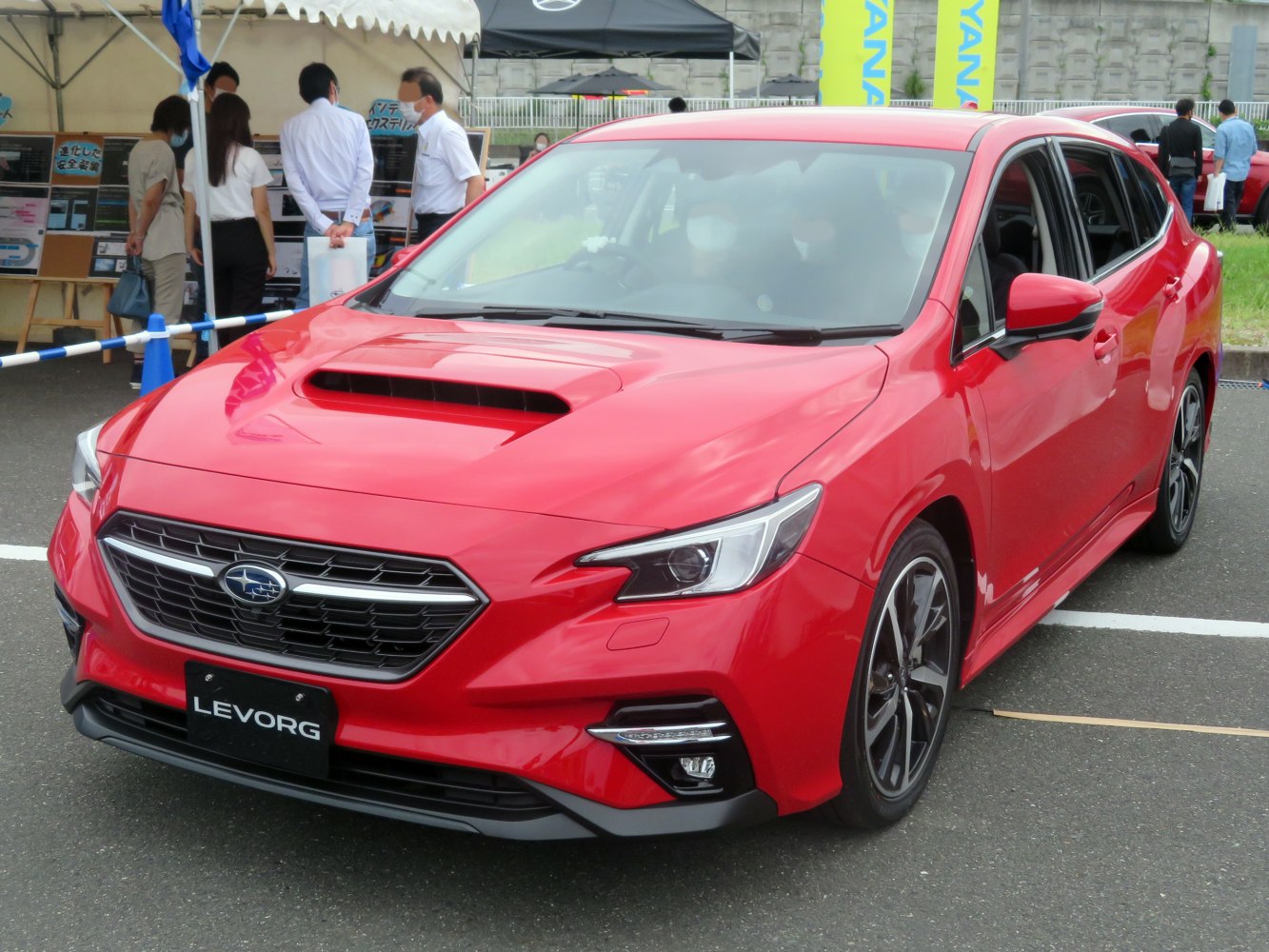 Red sporty vehicle front view with hood scoop and LED headlights