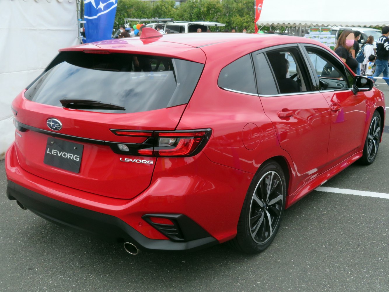 Rear and side view of a red modern sporty hatchback wagon with alloy wheels
