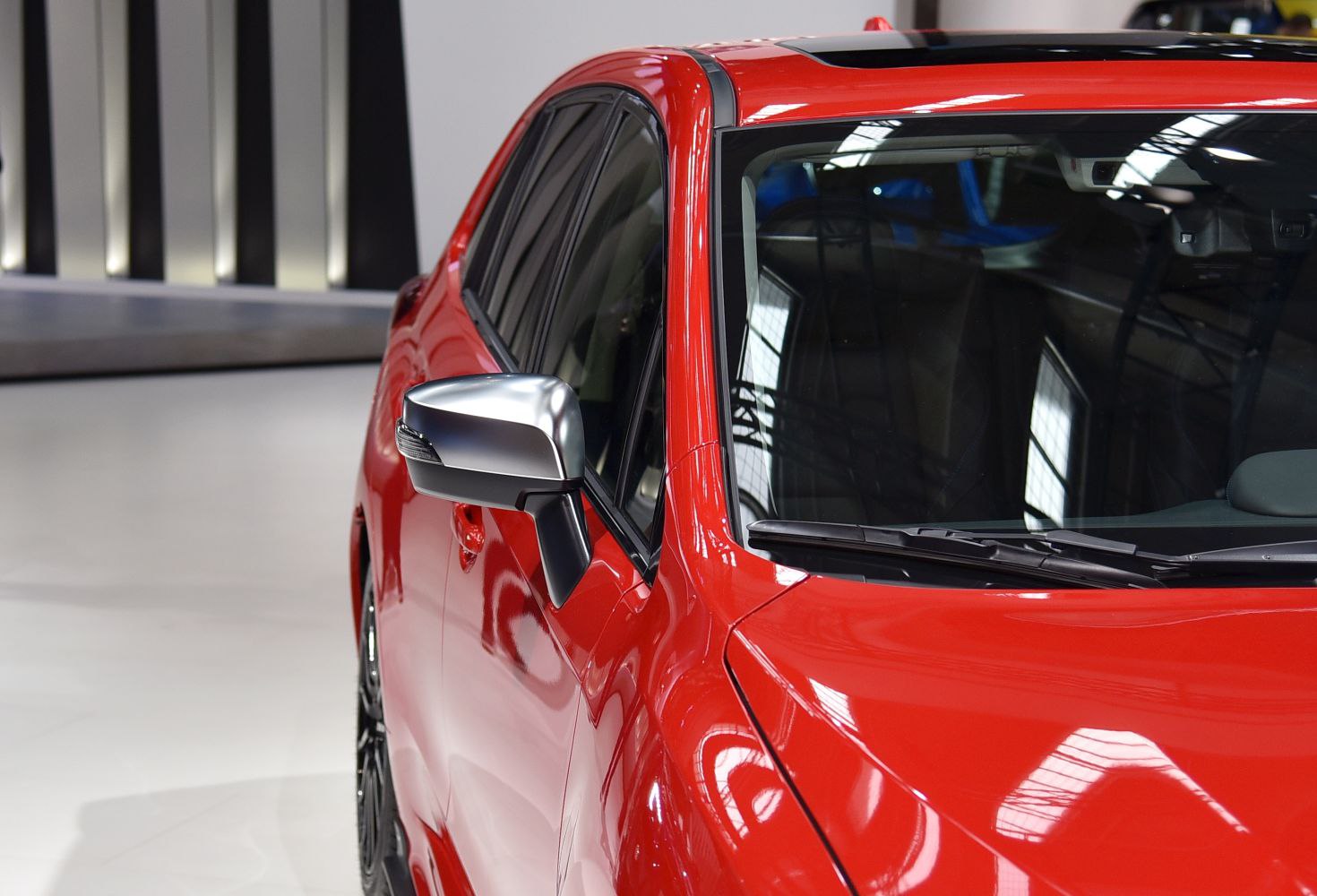 Side mirror and windshield close-up on red car