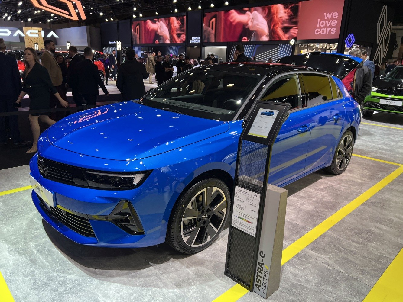 Electric hatchback in blue with black roof and modern front design.