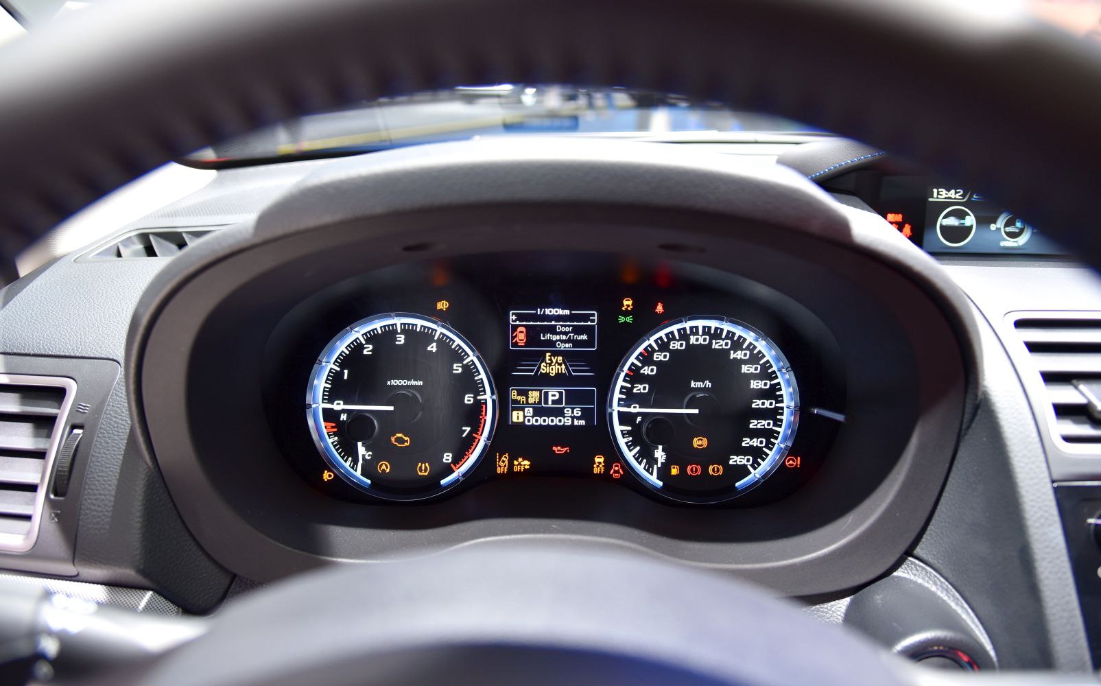 Instrument cluster with tachometer, speedometer, and digital warning displays