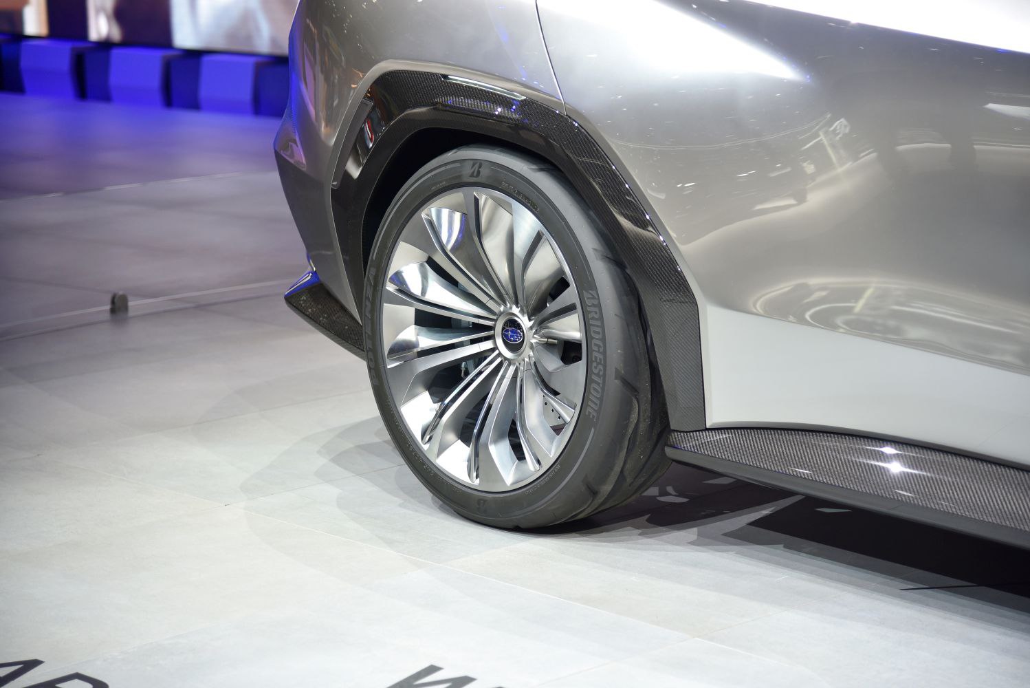 Rear wheel with intricate alloy design and carbon fiber trim