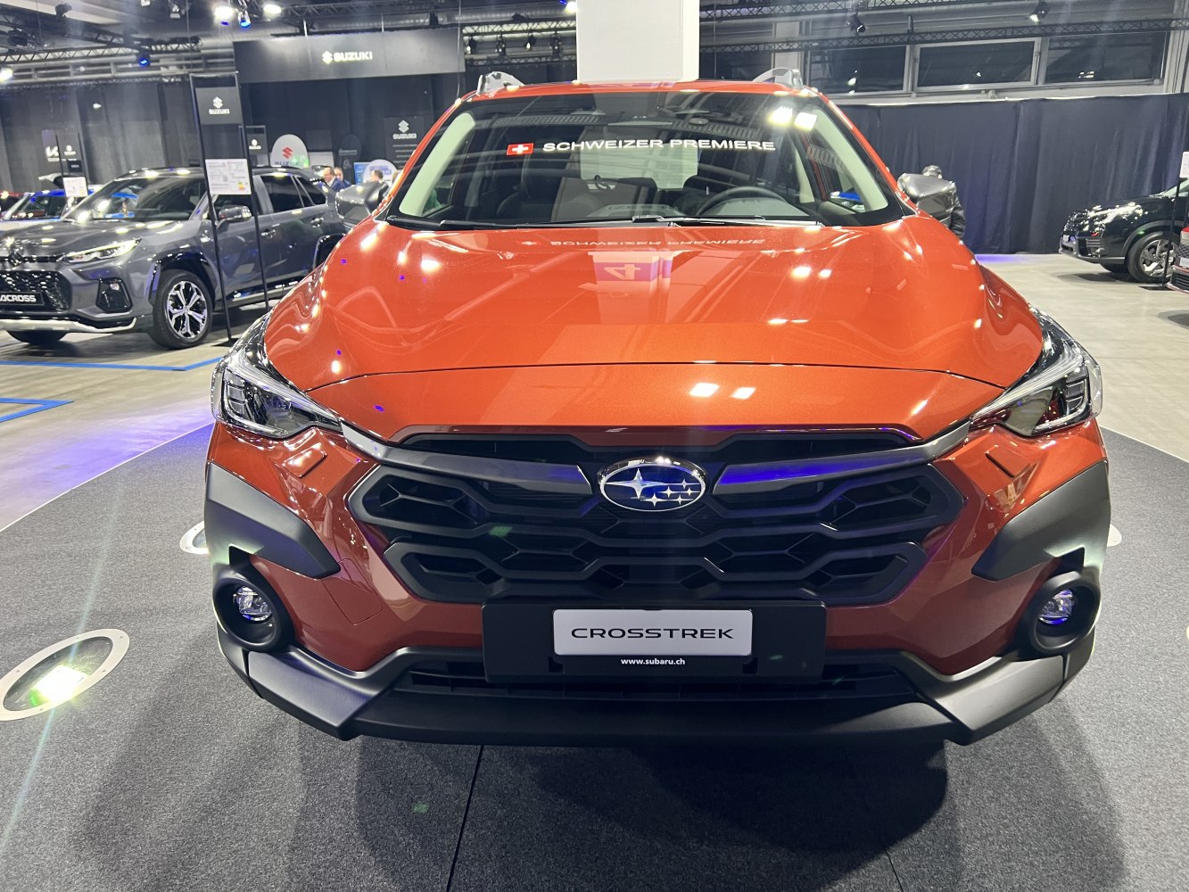 Front grille and headlights of an orange SUV.