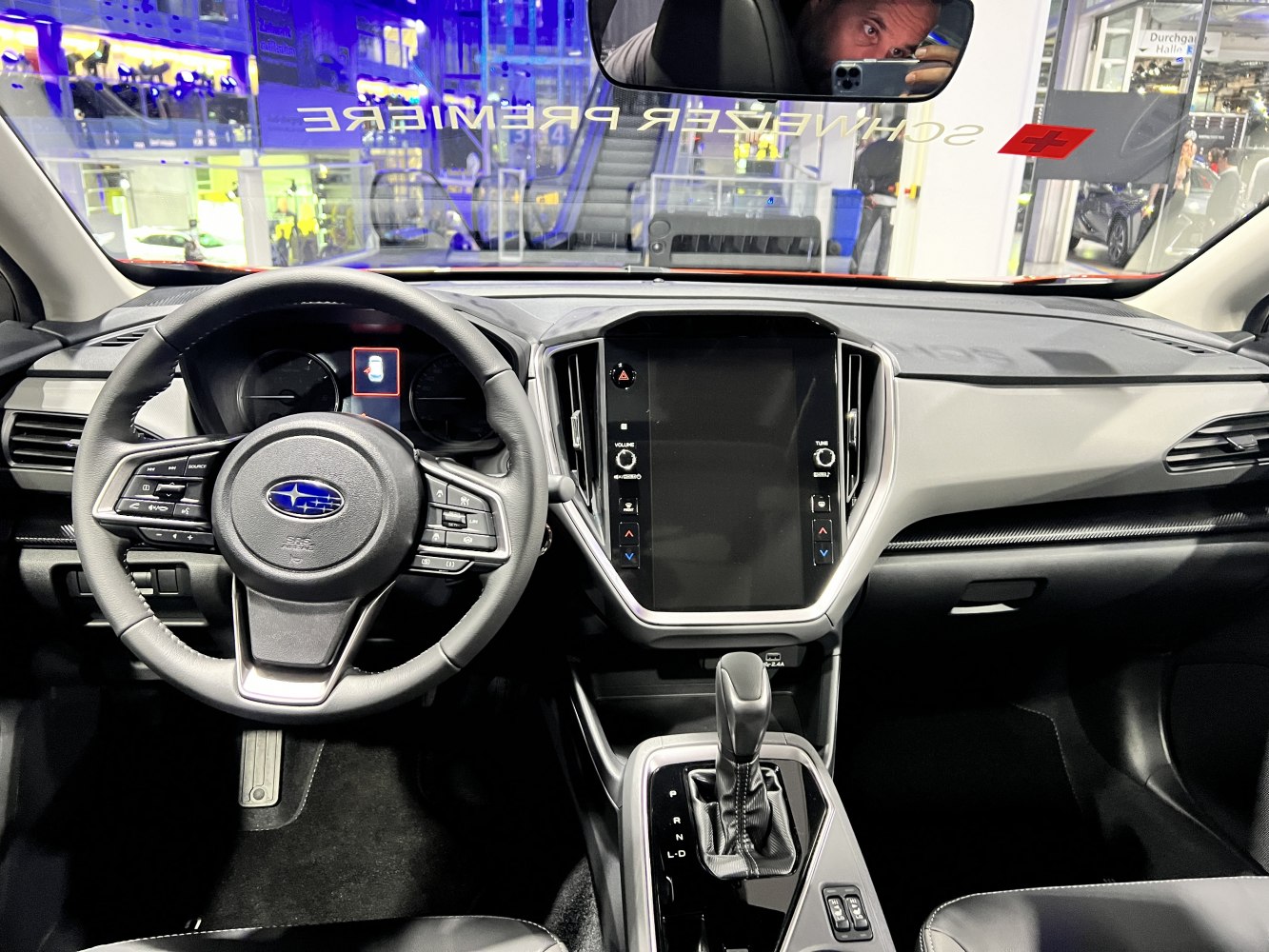 Interior cockpit with touchscreen, steering wheel controls, and gear shift lever