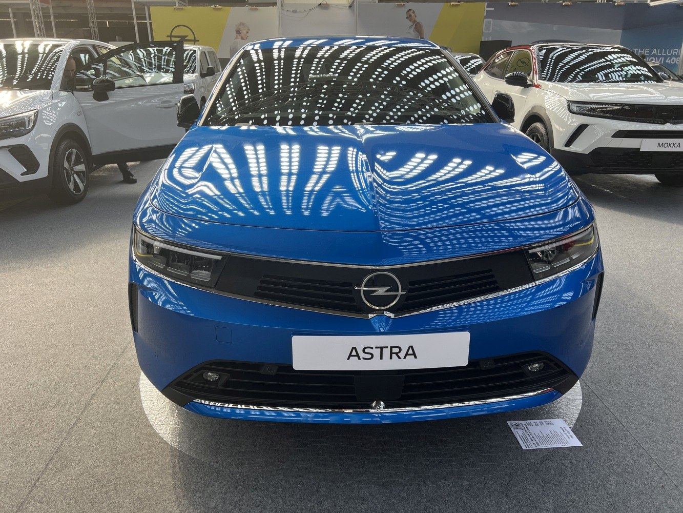 Front view of sleek hatchback with narrow headlights and bold grille